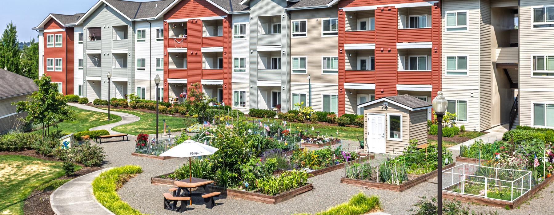 a spacious garden and picnic tables with an umbrella