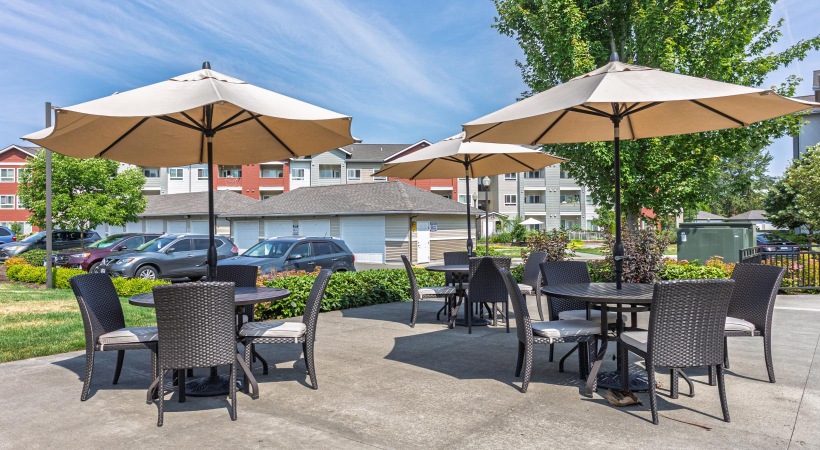 a group of tables and chairs with umbrellas