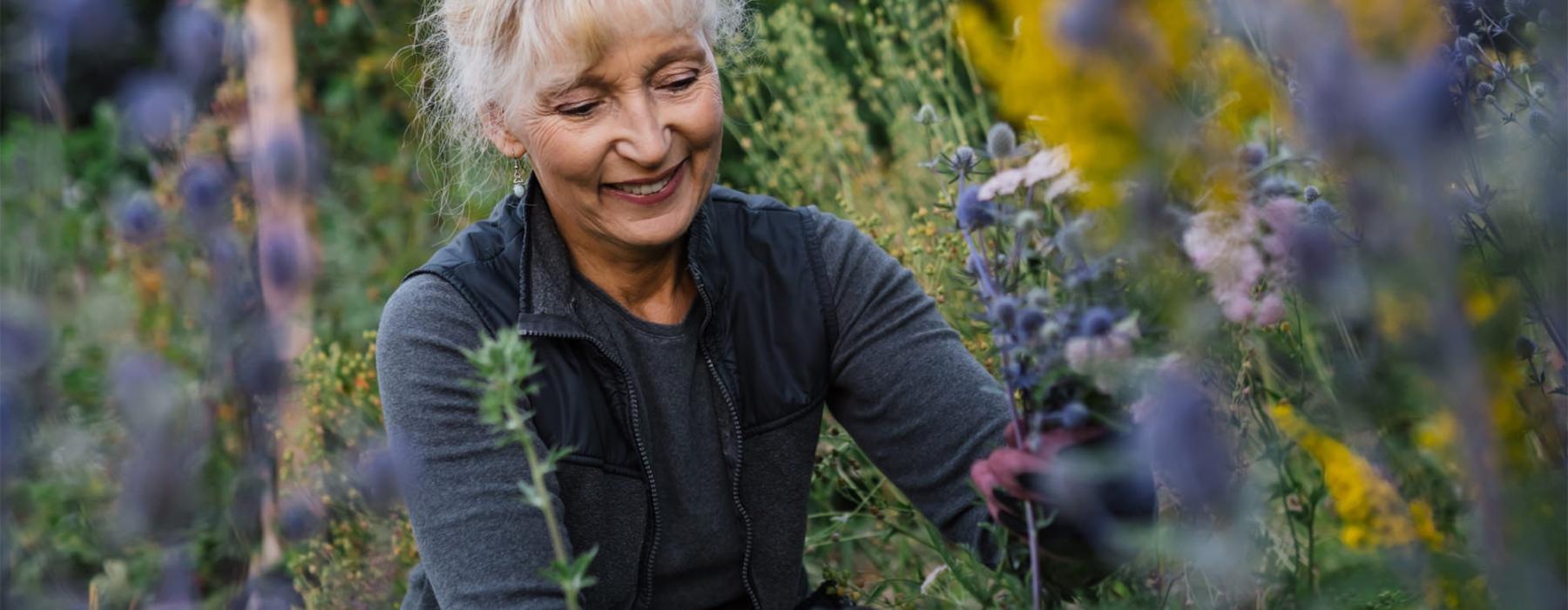 a woman kneeling in a field of plants